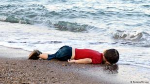 این عکس تصویری دلخراش است؛ تصویری که ابعاد وحشت‌برانگیز فراری نافرجام و مرگبار از کشور جنگ‌زده‌ی سوریه را نشان می‌دهد. این عکس فقط تصویربرداری کوچک و لحظه‌ای از اتفاقاتی است که هر روزه در سواحل دریای مدیترانه می‌توان شاهد آن بود.